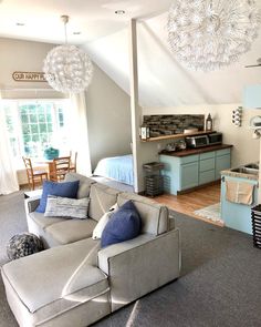 a living room filled with furniture next to a kitchen