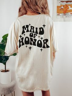 a woman wearing a white shirt that says friend of honor