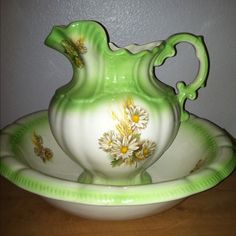 a green and white vase sitting on top of a bowl