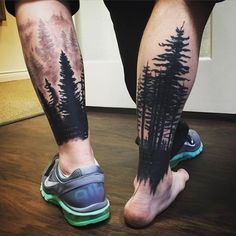 a person with tattoos on their legs and trees in the woods behind them, standing on a wooden floor