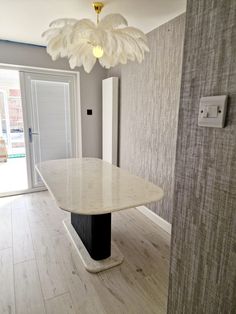 an empty room with a marble table and light fixture