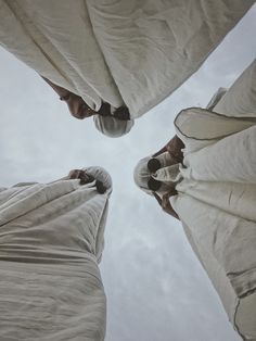 looking up at the top of two umbrellas with people standing under them and holding their hands together