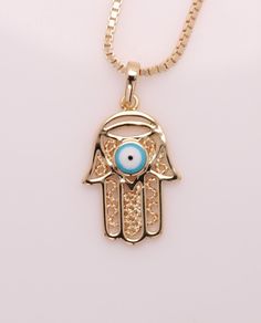 Brilliant Hamsa Hand Shape Evil Eye Pendant made from Gold-filled metal  Yellow Tone lasting alloy Pendant size: 22 mm tall (a little bit less of an inch) 18' inch chain + Gift box Evil Eye Symbolic Metal Jewelry, Evil Eye Pendant Amulet Necklace, Blue Evil Eye Metal Necklace, Evil Eye Hand, Hamsa Hand Pendant, Evil Eye Hamsa, Light Blue Eyes, Gold-plated Evil Eye Amulet Necklace, Yellow Tone