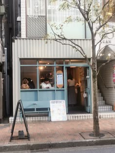 the outside of a restaurant with people sitting at tables in front of it and on the sidewalk