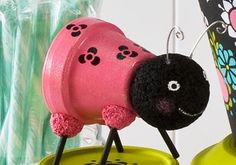 a pink and black toy sitting on top of a green table next to a vase