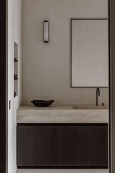 a bathroom sink with a mirror above it and a bowl on the counter in front of it