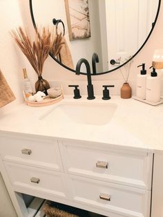 a bathroom sink with a round mirror above it