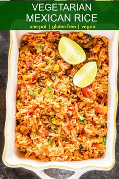 mexican rice in a white casserole dish with lime wedges on the side