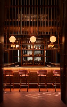 a dimly lit bar with three stools