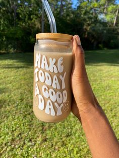 someone holding up a cup with a straw in it that says make today a good day