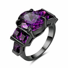 a ring with purple stones on the sides and black metal band, set against a white background