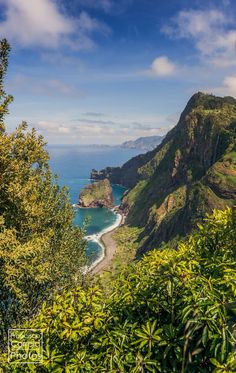 the ocean is surrounded by mountains and trees