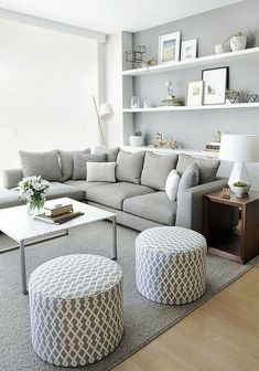 a living room filled with lots of furniture next to a wall mounted book shelf and window