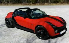 a red and black car is parked in the snow