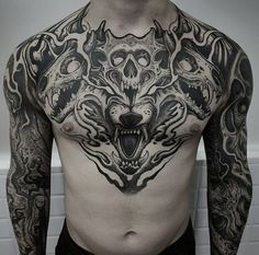 a man with tattoos on his chest has an angry wolf head tattoo on his chest