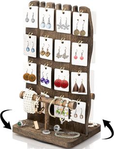 a wooden display with earrings and necklaces on it