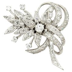 Gorgeous vintage style brooch bursting with incredible sparkle. This absolutely beautiful brooch is made of 14 karat white gold and arranged in a horizontal layout. It features 73 icy white natural round brilliant diamonds set in a clustered floral motif with swirling ribbon-like accents. The gentle curve of the piece adds a feminine touch and makes the glittering stones really pop. The diamonds are all set in polished white gold, truly enhancing their white brilliance. Also features a single hi Luxury White Hallmarked Brooches, Luxury White Round Brooch, Luxury White Flower Brooches, Vintage White Gold Brooches With Brilliant Cut, White Brilliant Cut Brooches For Wedding, White Brilliant Cut Wedding Brooches, Classic White Diamond Brooches, Floral Ribbon, Antique Brooches