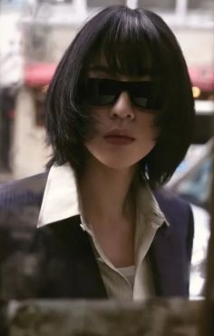 a woman with black hair and sunglasses on