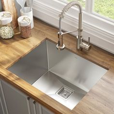 a stainless steel kitchen sink on a wooden countertop