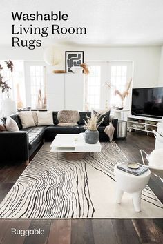 a living room with zebra print rugs and black leather couches in the center