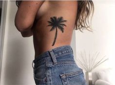 a woman with a palm tree tattoo on her back