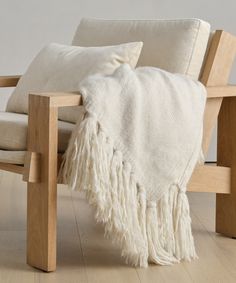 a wooden chair with a white blanket on it