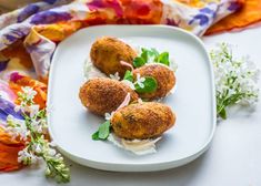 three appetizers on a white plate with flowers