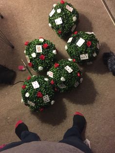 someone is sitting on the floor next to some christmas wreaths that have been made out of baby shower balls