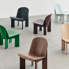 several different colored chairs sitting in a circle on the floor, all facing one another