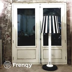 a lamp that is sitting on top of a pole in front of a door with the word friendly written below it