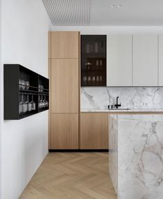 a modern kitchen with marble counter tops and wooden cabinetry, along with an island in the middle