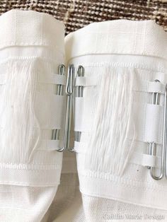 two white towels with metal clips attached to them