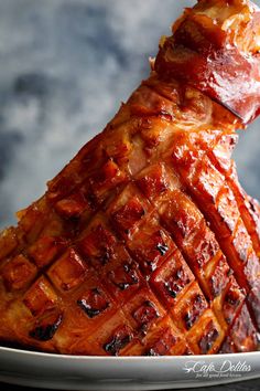 a large piece of meat sitting on top of a white plate next to a fork