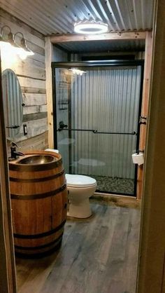 a bathroom with a wooden barrel next to a toilet