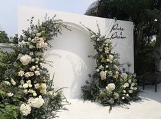 white flowers and greenery are arranged around the entrance to a private residence in miami