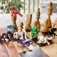 several toy figurines sitting on top of a chess board