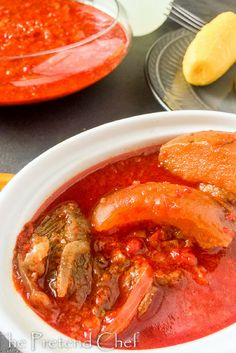 there is a bowl of soup with meat and vegetables in it on the table next to other dishes