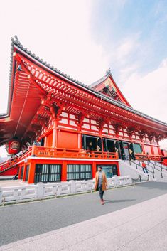 a person walking in front of a red building