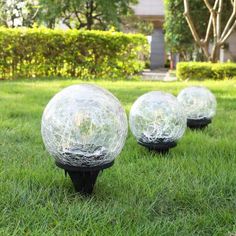 three glass balls are sitting in the grass