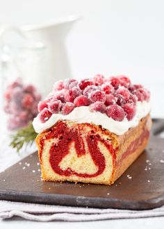 a piece of cake with white frosting and raspberry toppings on top