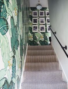 the stairs are decorated with green and white wallpaper