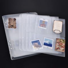 three clear binders with pictures and stamps on them, one has a clipboard attached to it