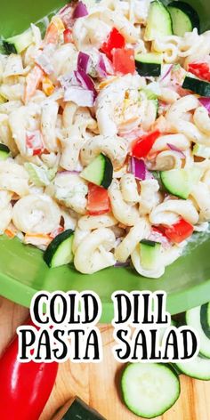 pasta salad with cucumbers and tomatoes in a green bowl