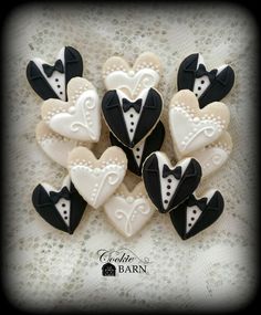 decorated cookies in the shape of tuxedo, bow tie and heart on a lace tablecloth