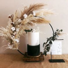 a white and black vase sitting on top of a wooden table next to a sign