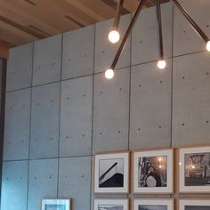 several framed photographs hang on the wall above a dining room table with utensils