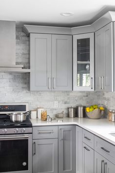 a kitchen with gray cabinets and stainless steel appliances