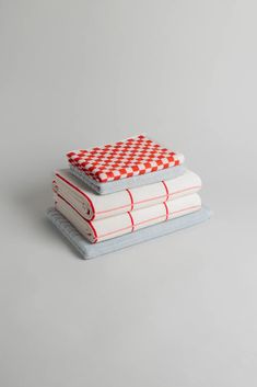 three books stacked on top of each other with red and white checkered coverings