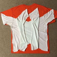 an orange and white t - shirt is laying on the floor next to it's cutout