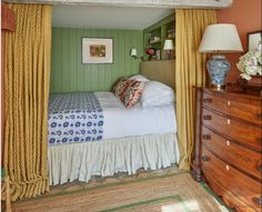 a bed sitting under a window next to a dresser